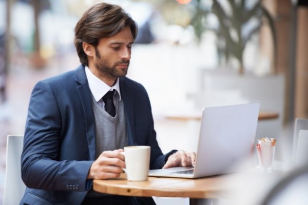 Man working on laptop computer at desk.