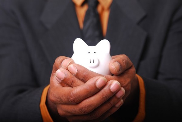 Man holding white ceramic piggy bank