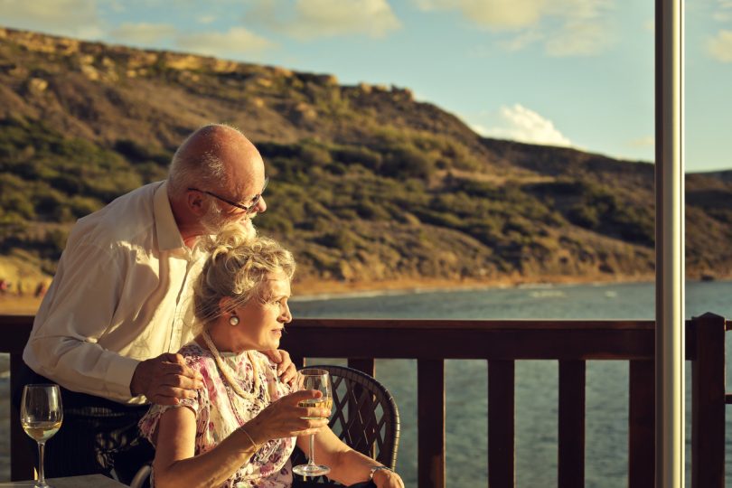  Old couple are watching the sunset on the beach.