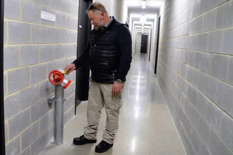 Alistair checking a fire-hose connection point in The Pier building at Kingston Foreshore.