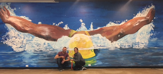  Felicity Galvez with artist Geoff Filmer who with his father Pete painted the mural of Galvez in full flight that adorns her new fitness studio. Photos: Supplied.