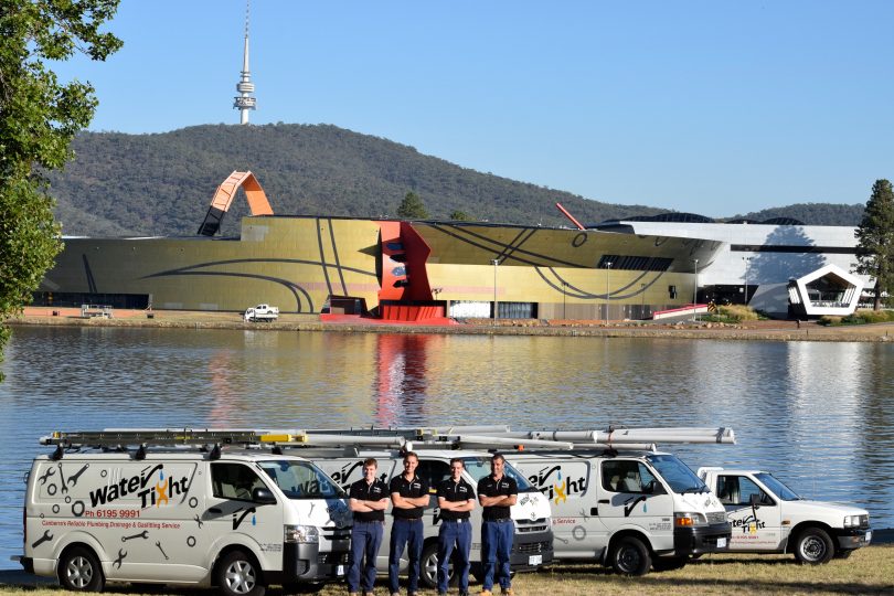 Water Tight Plumbers tradesmen posing with branded vans at Lake Burley Griffin.