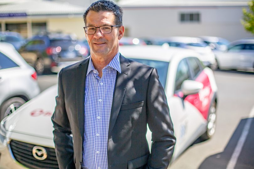 Bendigo Bank's Peter Grady standing in front of car. 