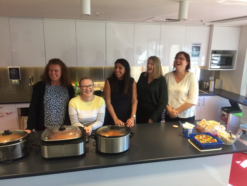 BAL Lawyers staff standing in kitchen enjoying Curry Club.