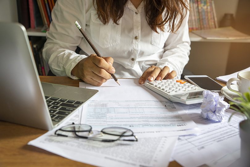 Woman sitting at desk working on tax return.