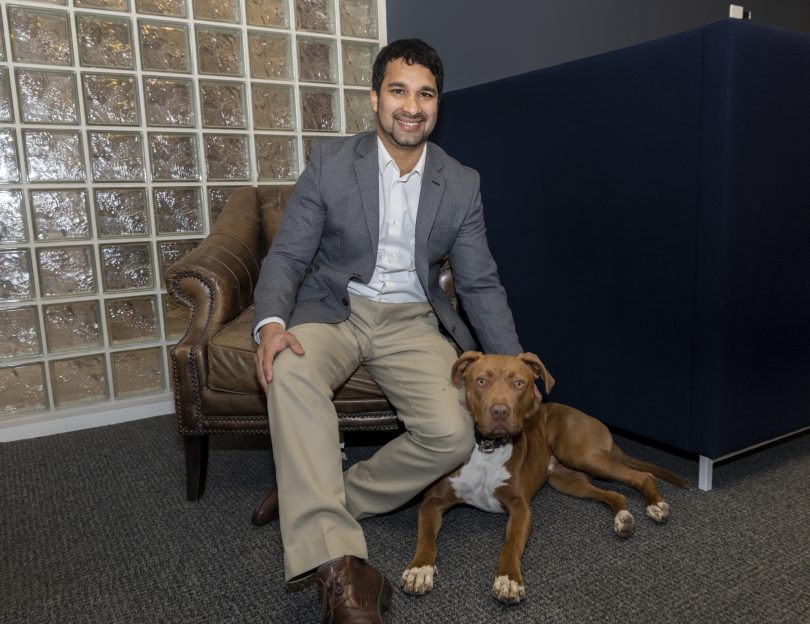 Kirk Fonseca sitting with his dog, Roman.