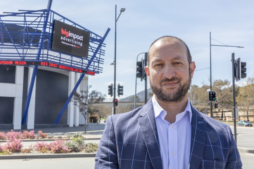 MJ Qual standing in front of digital billboard.