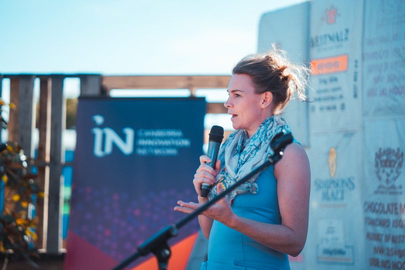 Rachael Greaves onstage with microphone at 2019 Innovation Showcase.