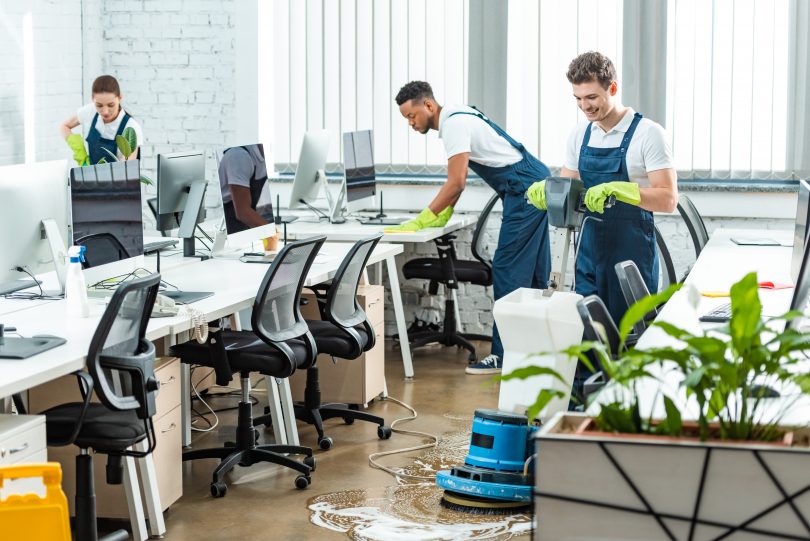 Team of cleaners working in modern open space office