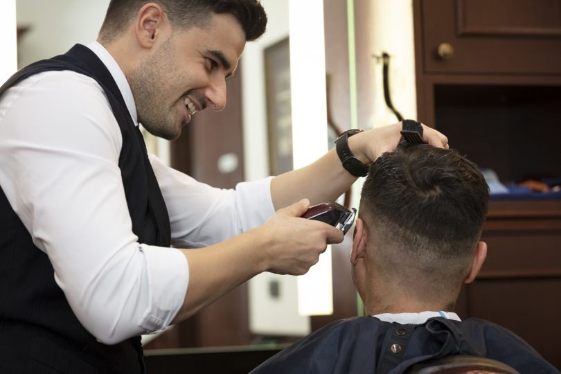 Barber cutting man's hair at Truefitt & Hill