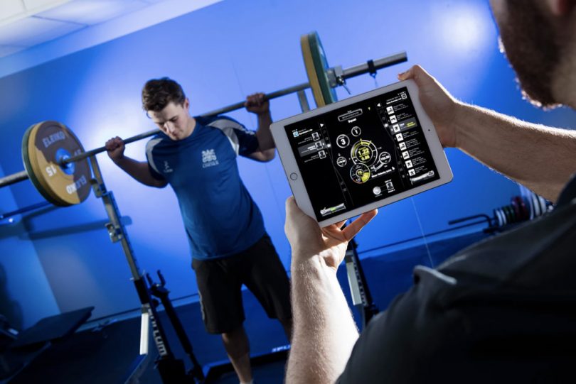 Man lifting weights while computer measures his output