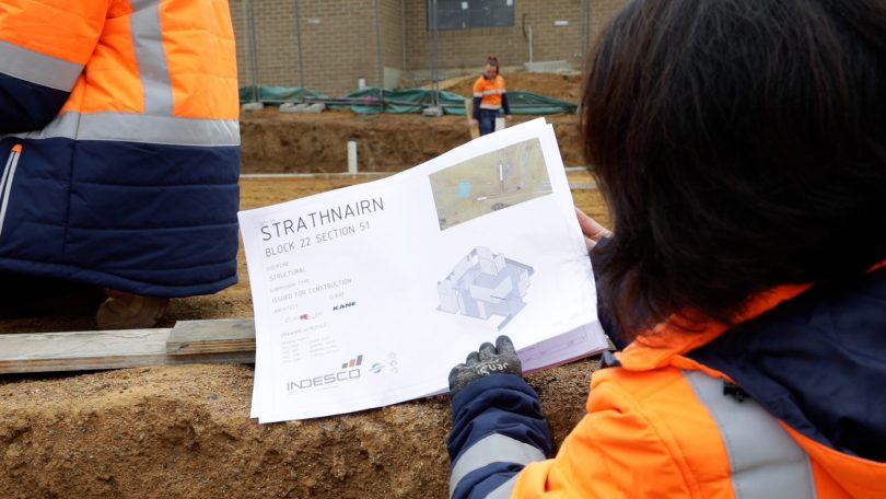 Woman reading plan on construction site