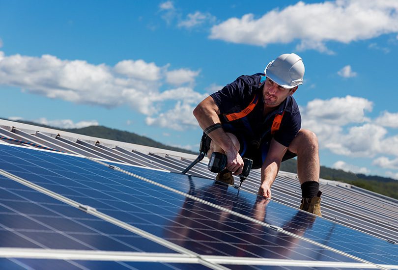 Workman on roof installing solar system