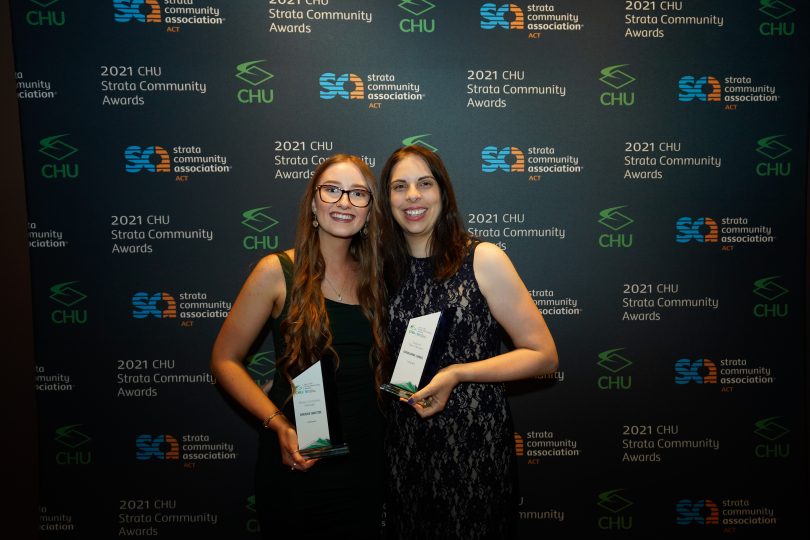 two people holding awards