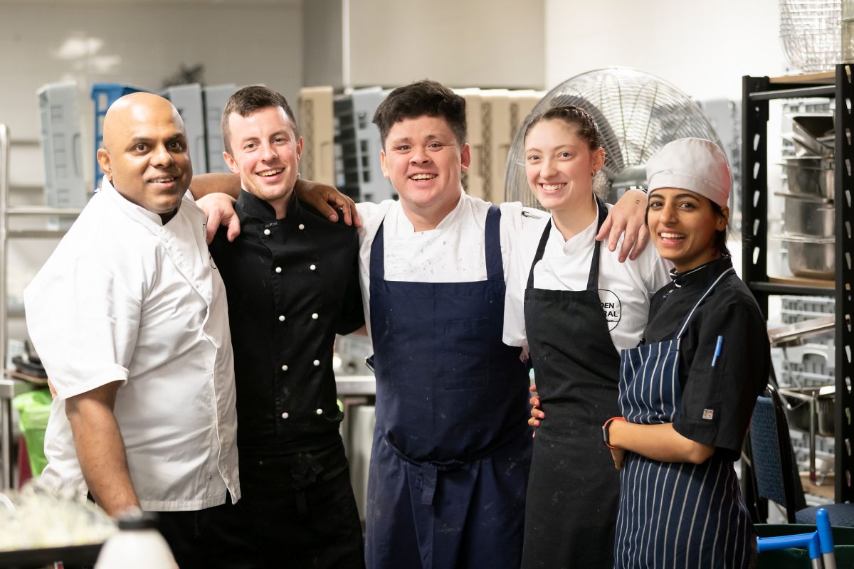 Five kitchen staff arm in arm